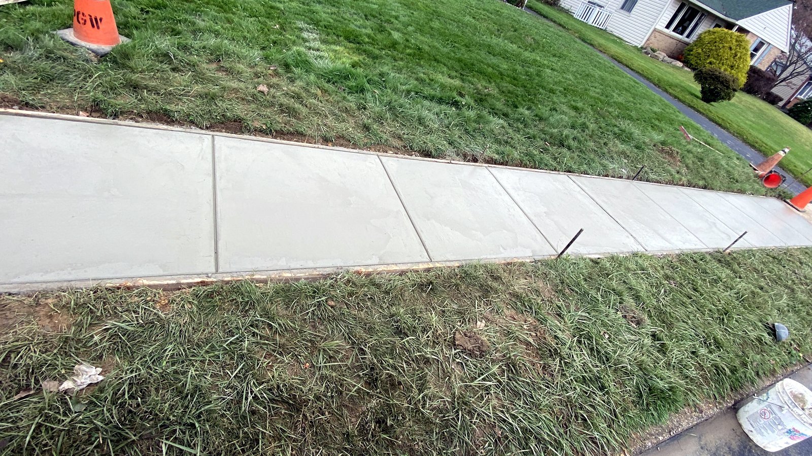 New concrete sidewalk running along a grass strip