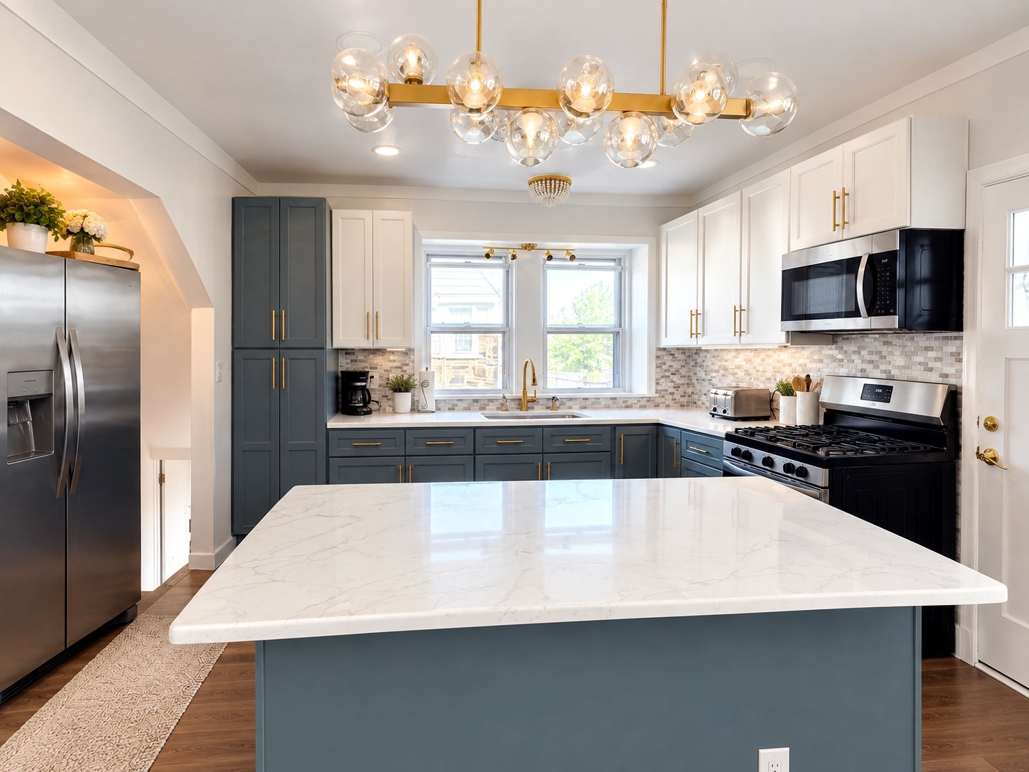 Renovated kitchen with slate-blue island, quartz countertops, and gold fixtures