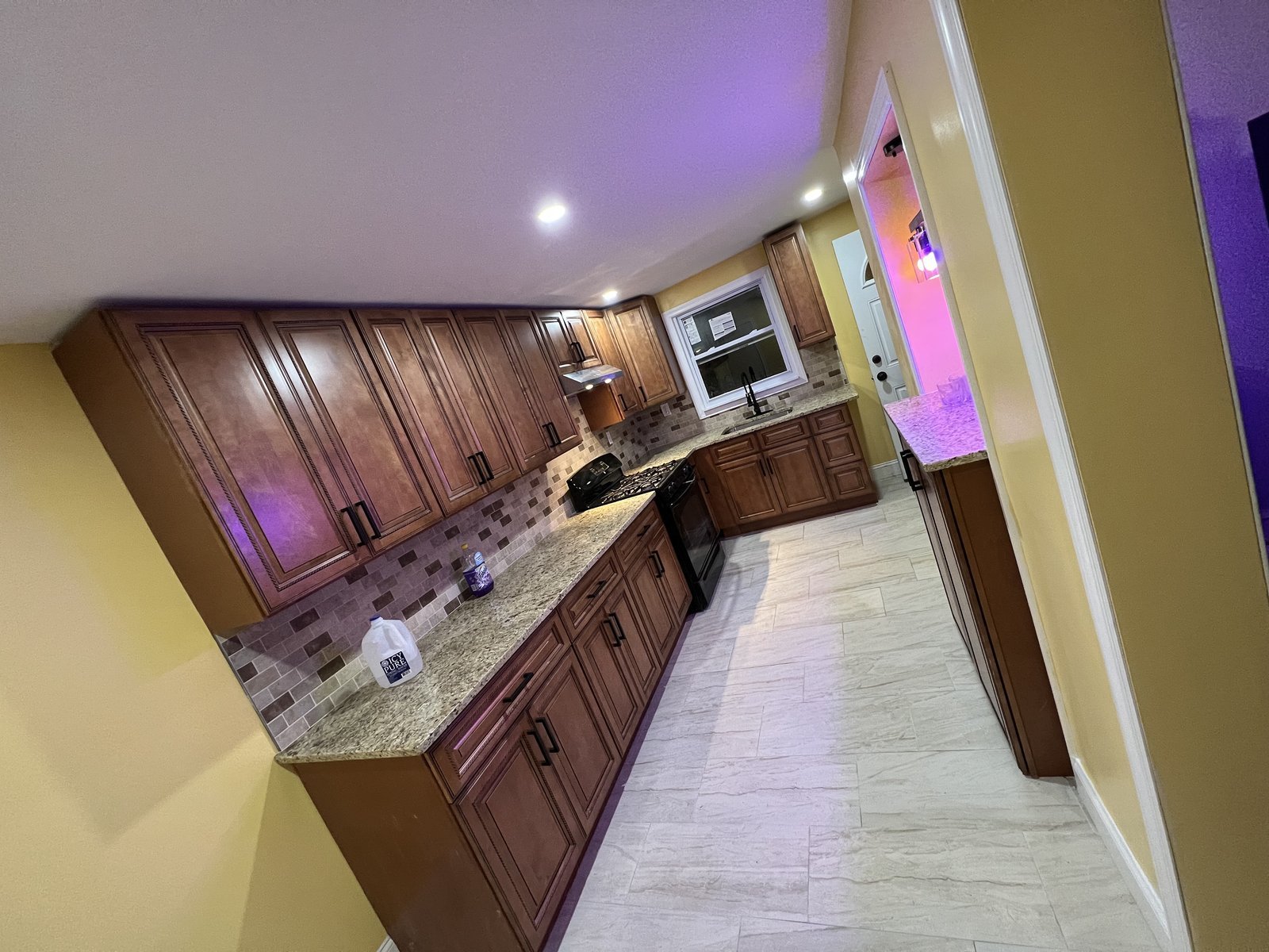Kitchen with cherry cabinets, granite counters, and a glass tile backsplash
